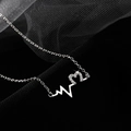 Detailed close-up of 925 silver heart necklace with sparkling pavé stones on black mesh - White Gold