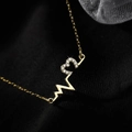 Macro shot of 925 silver heartbeat necklace with sparkling pavé cubic zirconia - Gold