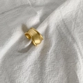 Macro shot of wide irregular wavy gold ring with matte texture on white fabric - Wide Irregular Wave Style (R702)