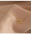 Close-up of infinity heart pendant in 18K gold with shimmering crystals on satin - Gold
