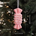 Pink glitter candy Christmas ornament hanging on a green tree with warm bokeh lights - Pink Candy