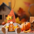 Detail of fall gnome ornament with orange knit hat, sunflower, and maple leaf decorations - Knitted Hat Braids Style