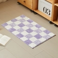 Tappetino da bagno a scacchi viola e bianco su pavimento in legno in ambiente accogliente - 40x60cm / Scacchiera Viola