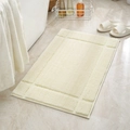 Tappeto da bagno beige spesso e assorbente con bordo a greca su pavimento in marmo - 40x60 / crema