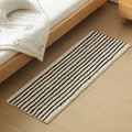 Minimalist black and white striped bedside rug on light wood floor in cozy bedroom - 40x60cm / Black