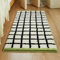 Tappeto di peluche a scacchi bianco e nero con bordo verde chiaro su pavimento in legno - 40x60cm / Verde