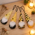 Detalle de cuatro gnomos abeja con sombreros de girasol y luces cálidas de ambiente - Modelo A Juego del Festival de las Abejas (Set de 4)