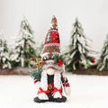 Christmas gnome doll with knit hat and wooden ski poles in a festive snowy scene - Brown Red