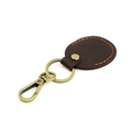 Detailed view of dark brown leather keychain with vintage bronze ring and orange stitching - Coffee