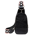 Close-up of black leather chest bag featuring a colorful geometric woven shoulder strap - Black