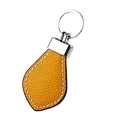 Close-up of ginger leather keychain with white hand-stitched details and silver ring - Yellow