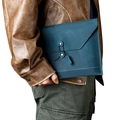 Close-up of blue leather laptop sleeve with string-and-button closure and hand-stitched detail - Blue