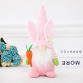 Gnome de Pâques rose en peluche avec oreilles de lapin et carotte sur une étagère - Style Lapin Rose