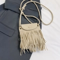 Modieuze beige franje emmertas met matte afwerking en lange schouderriem - Broken Wit