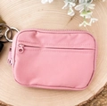 Pink waterproof nylon coin purse with a metal keychain displayed on a wood tray - Pink