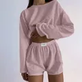 Close-up of pink knit loungewear set featuring delicate pointelle texture and logo label - Pink