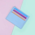 Portacarte sottile in pelle azzurra con tre scomparti su sfondo color pastello - Blu