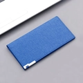 Lange Canvas-Geldbörse in Blau mit Denim-Textur und silbernen Metallecken auf grauem Tisch - Blau