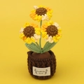 Detail von drei handgehäkelten Sonnenblumen im braunen Topf mit HandMade-Textetikett - Dreiköpfige Segmentgefärbte Sonnenblume - Dunkelbrauner Topf