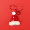 Detail of a handmade knitted Santa hat keychain with snowflake pattern and a small red bell - Snowflake Christmas Hat (Red Bell)