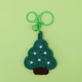 Detailed view of hand-crocheted green Christmas tree keychain with white snowflake motifs - Snowflake Christmas Tree (Green Bell)