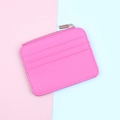 Macro detail of rose pink zipper card holder with pebble leather texture and card slots - Rose Red