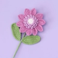 Detail of handcrafted crochet flower in purple with white center and green leaves - Purple