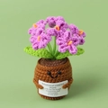 Close-up of handmade crochet puff flower potted plant with purple flowers and cute smiling face - Purple Forget-me-not