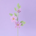 Handgehäkelter Jasminstrauß mit lila Garnblumen und grünen Blättern auf weichem Hintergrund - Lila