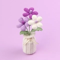 Handgefertigte gehäkelte Frangipani-Blumen in weißer Vase mit eleganter Schleifenverzierung - Verlauf Lila Frangipani (Garnvase)