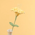 Detail von handgehäkelter gelber Lilie in weißer Keramikvase mit grünen Blättern und Stiel - Gelb