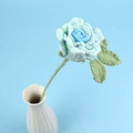 Handgefertigte Häkelrose in Mintgrün und Blau in einer weißen Keramikvase - Verlauf Blau