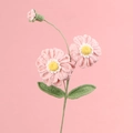 Handgefertigte gehäkelte Zinnienblume mit rosa Blütenblättern und grünen Blättern - Rosa