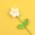 Handgefertigte Häkelblume mit weißen Blütenblättern und gelber Mitte auf gelbem Grund - Weiß