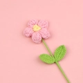Handgehäkelte Pusteblume in Rosa und Gelb mit grünen Blättern auf rosa Hintergrund - Rosa