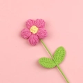 Dettaglio ravvicinato di un fiore rosa lavorato a maglia a mano con foglie e centro giallo - Rosa Rosso