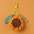 Handmade crochet sunflower keychain with green leaf and orange tag on orange backdrop - Sunflower (Multiple Accessories)