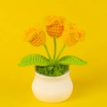 Detail von drei handgehäkelten orangefarbenen Tulpen in weißem Keramiktopf auf gelbem Grund - Dunkelgelb 3-Kopf Maiglöckchen