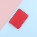 Slim red faux leather card holder with white stitching on vibrant split background - Red