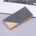 Minimalist long canvas wallet in grey and khaki stitching placed on a modern desk setup - Black