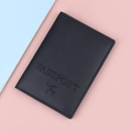Slim black PU leather passport holder featuring embossed text and airplane icon design - Black