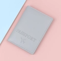 Grey PU leather passport cover with embossed airplane icon on pink and blue background - Gray