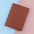 Caramel brown leather passport cover featuring a debossed airplane icon and stitched edges - Brown