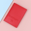 Red textured leather passport holder cover featuring embossed aircraft and passport text - Red