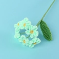 Detail of handmade crochet forget-me-not flower with mint green petals and yellow stamens - Green