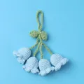 Close-up of handmade crochet Lily of the Valley charm with light blue flowers - Blue