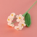 Close-up of handmade crochet forget-me-not bouquet with pink flowers and green leaf - Korean Pink