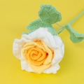 Close-up of handmade crochet rose with white petals and yellow center on stem - Gradient Yellow
