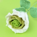 Close-up of handmade crochet rose with white petals, green core and knitted texture - Gradient Green