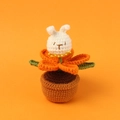 Hand-crocheted rabbit in orange flower potted plant with handmade knitted texture - Orange